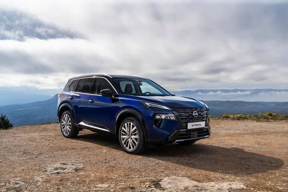 {"fr":"Nissan X-Trail bleu garé sur un terrain montagneux sous un ciel nuageux.","nl":"Blauwe Nissan X-Trail geparkeerd op bergachtig terrein onder een bewolkte hemel."}