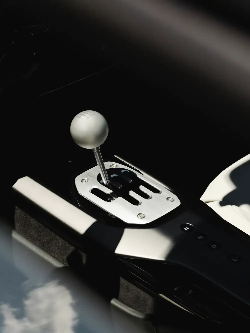 Levier de vitesses en métal argenté dans une voiture de sport moderne, accent sur les détails.
