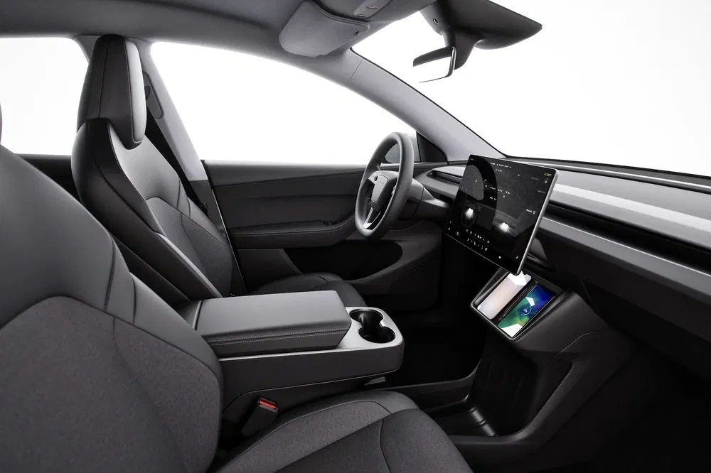 Intérieur moderne de Tesla Model 3 avec écran tactile central et sièges élégants.