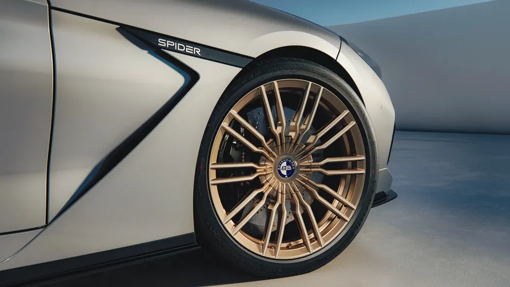 Roues en alliage doré de la Maserati MC20 Cielo Spider sur surface bétonnée.