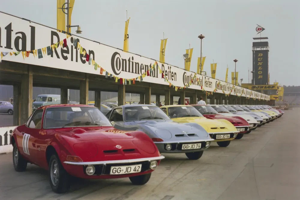 Opel GT auto's in kleurrijke rij opgesteld in pit lane van de Nürburgring.