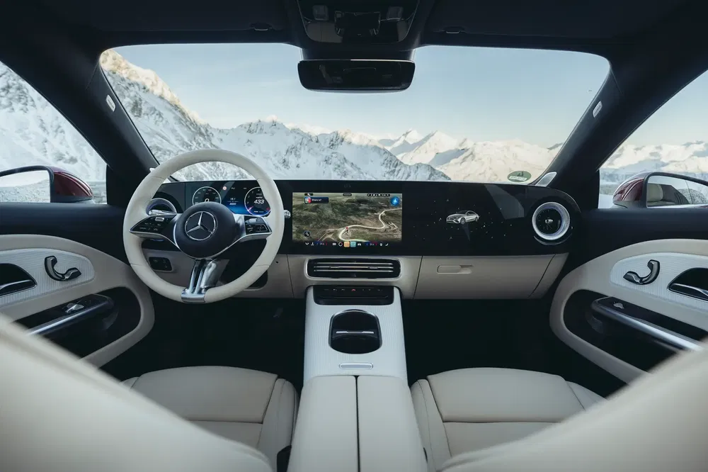 Interieur van Mercedes auto met touchscreen, uitzicht op besneeuwde bergen op de achtergrond.