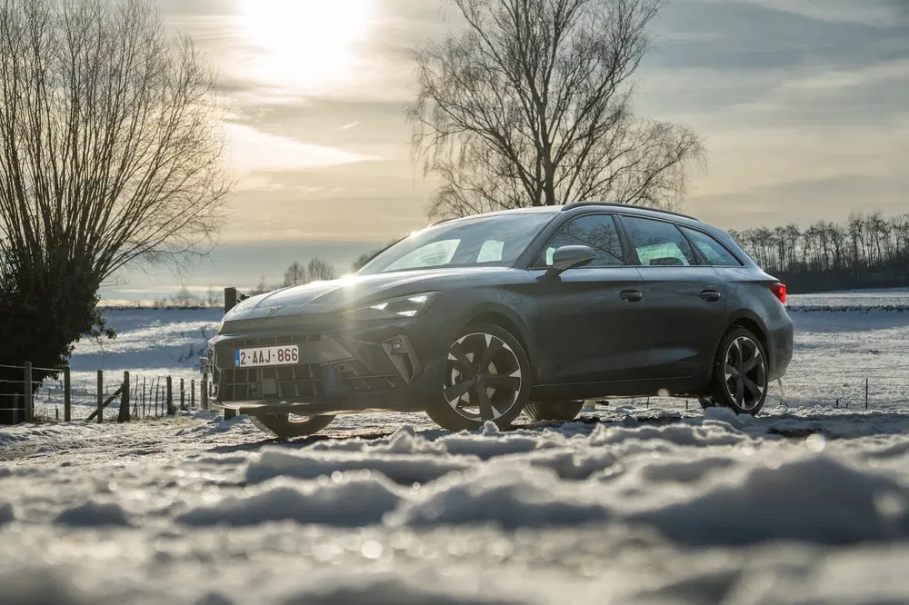 Opel Astra Sports Tourer in winter, besneeuwd platteland, lage zon aan de horizon.