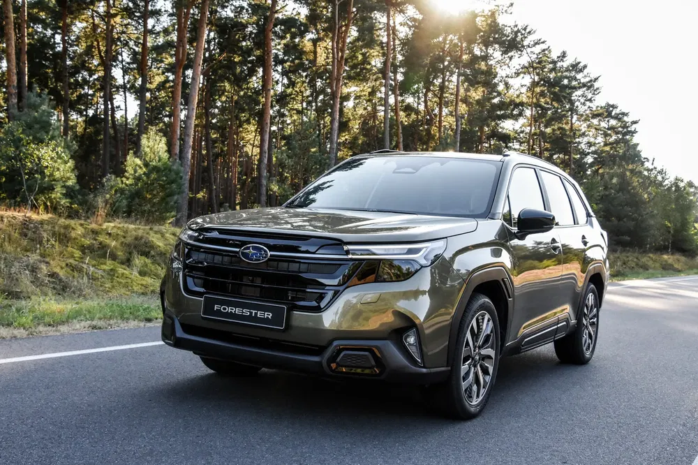 Subaru Forester op zonnige bosweg, moderne en stevige SUV.