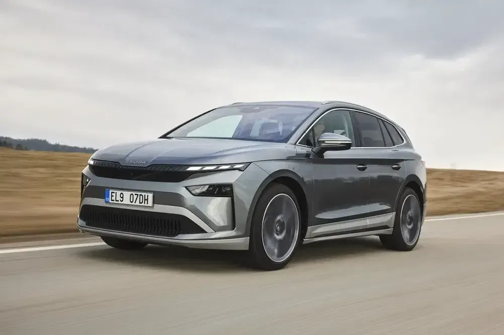 Škoda Enyaq Coupé rijdt op snelweg, modern en aerodynamisch ontwerp onder bewolkte hemel.