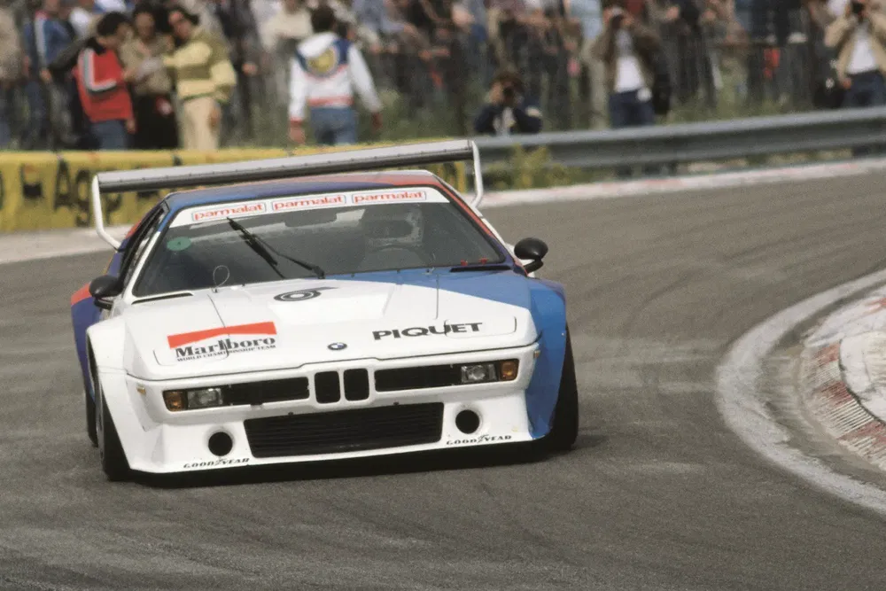 BMW M1 Procar de course prenant un virage serré sur circuit.
