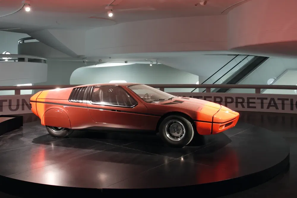 Concept car BMW Turbo rouge sur podium, intérieur moderne d'une exposition automobile.