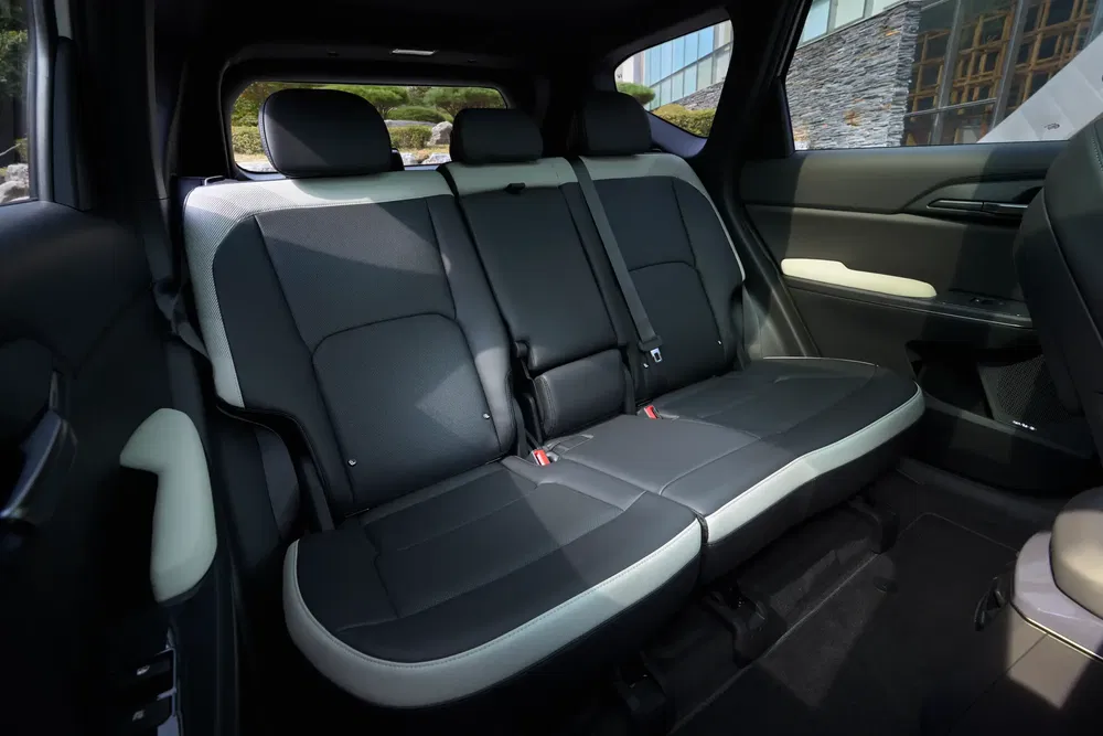 Intérieur de voiture moderne avec sièges arrière en cuir noir et accoudoirs contrastés.