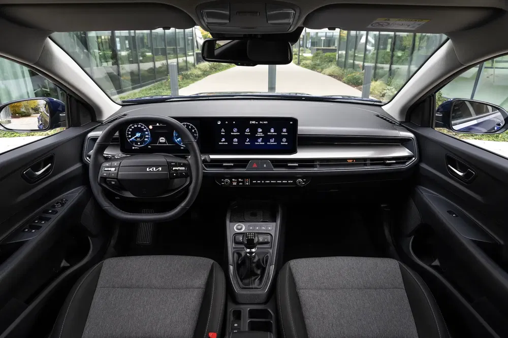 Interieur van een Kia met eigentijds touchscreen, multifunctioneel stuur en strak ontwerp.