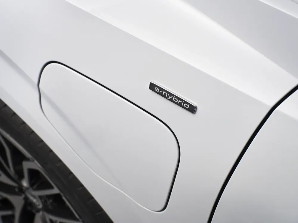 Étiquette "e-hybrid" sur la carrosserie blanche d'une voiture électrique moderne.
