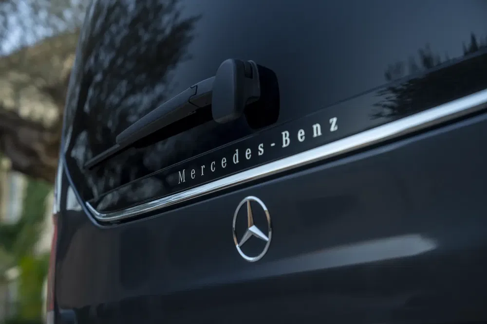 Mercedes-Benz logo op achterklep van een donker voertuig.