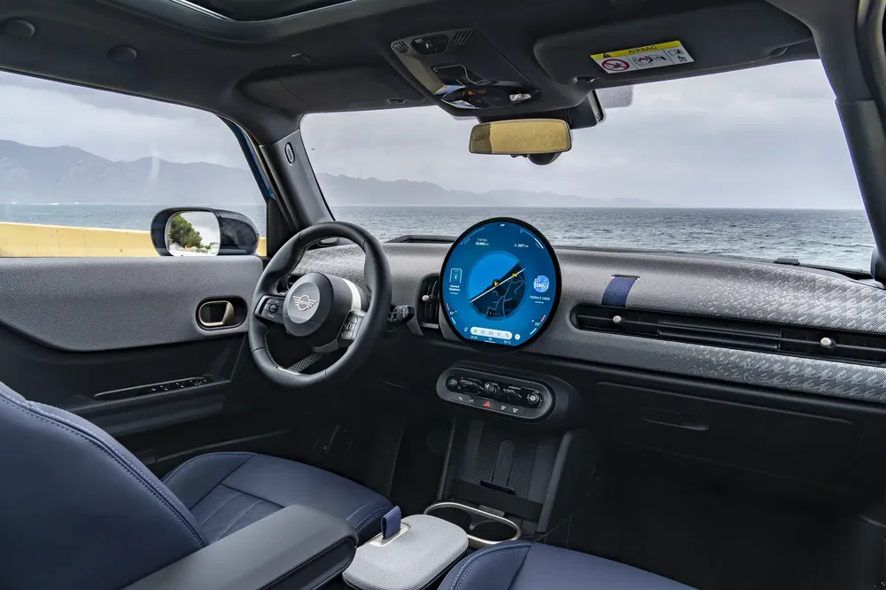 Intérieur moderne d'une Mini avec écran tactile, vue mer en arrière-plan.