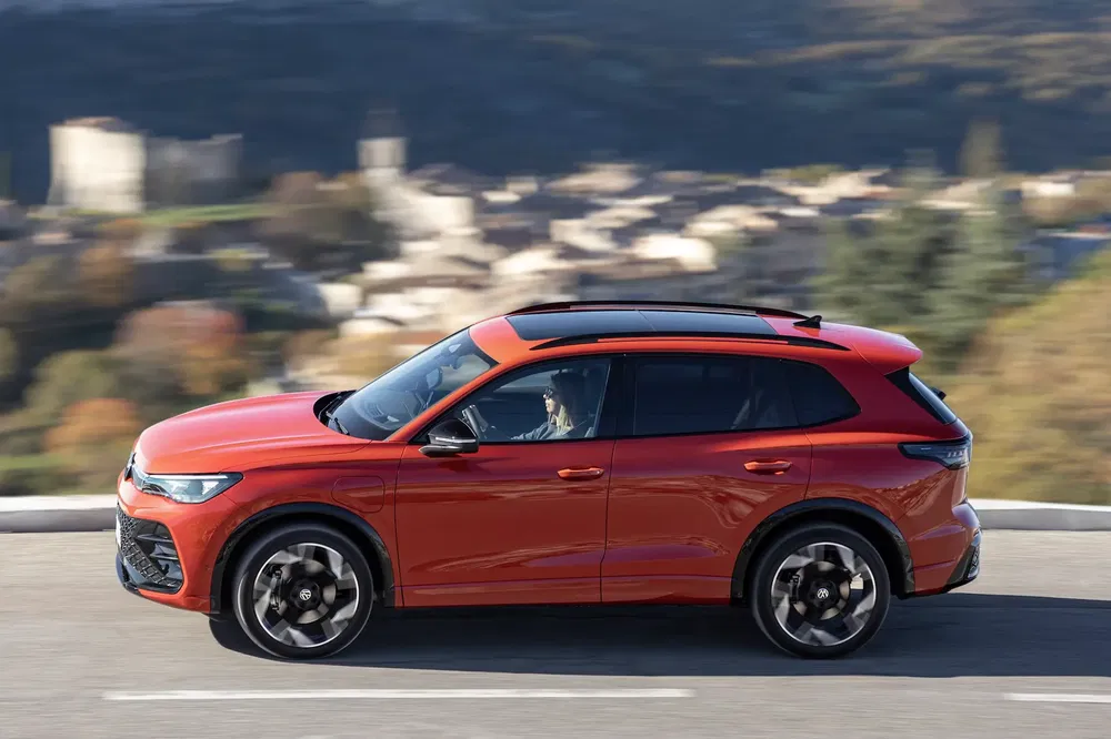 SUV MG en mouvement sur route, paysage en arrière-plan flou.