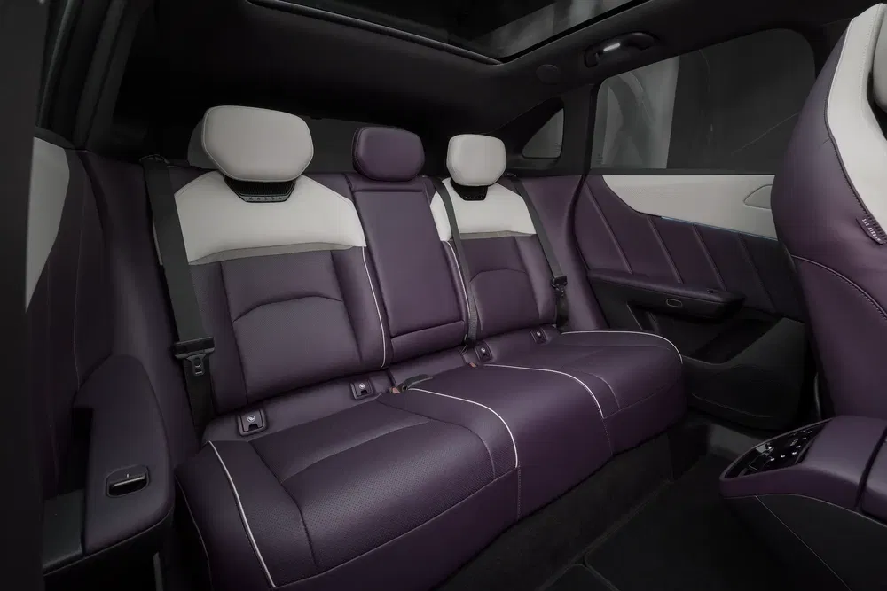 Intérieur arrière d'une voiture avec sièges en cuir violet et blanc de luxe.
