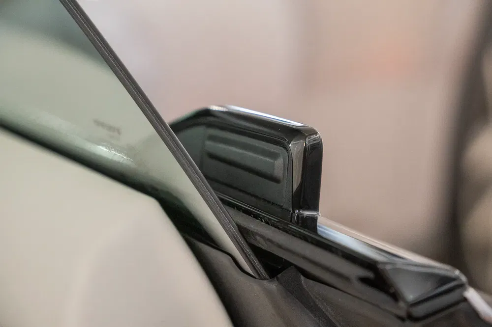 Détail du rétroviseur d'une voiture moderne, aspect aérodynamique et minimaliste.