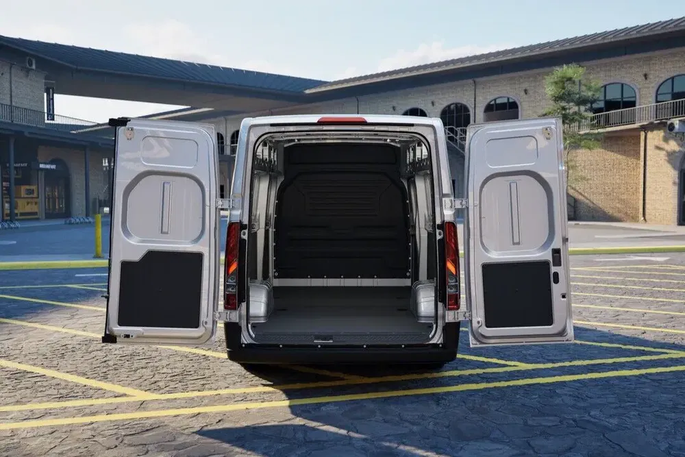 Ford Transit bestelwagen met geopende achterdeuren op parkeerplaats, toont ruime binnenkant.