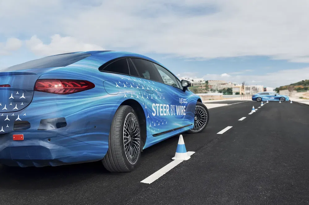 Blauwe Mercedes EQE op een circuit met 'Steer By Wire' technologie.