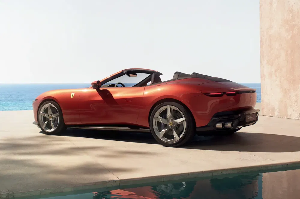 Rode Ferrari Roma Spider aan zee, elegante en moderne stijl.