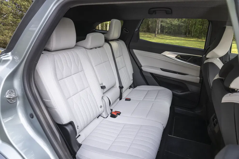 Binnenkant SUV met witte leren achterbank en moderne afwerking.