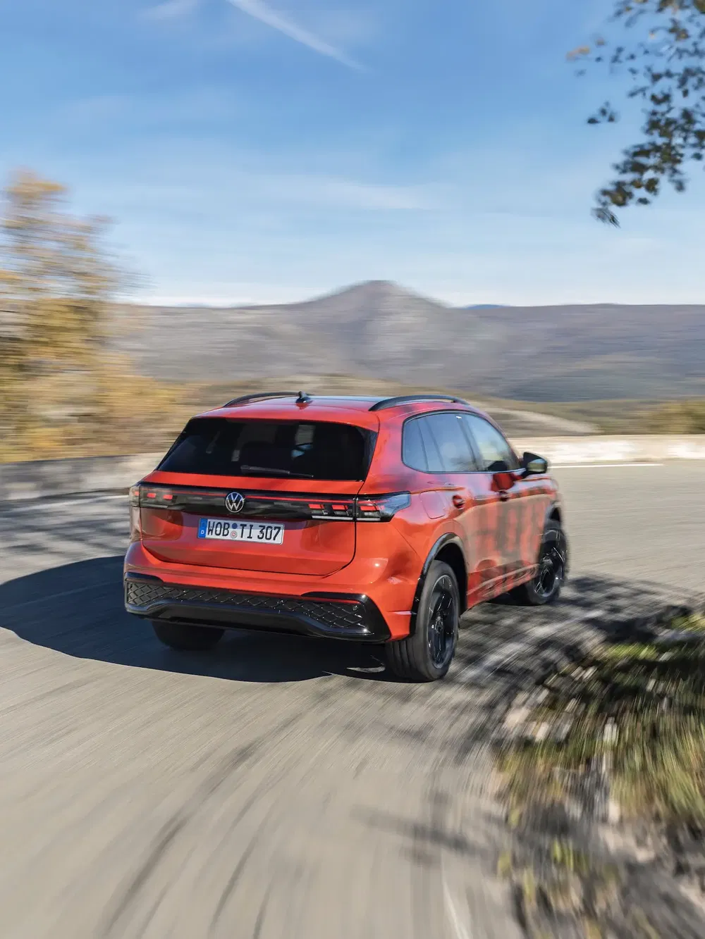 Volkswagen ID en mouvement sur une route sinueuse de montagne en automne.