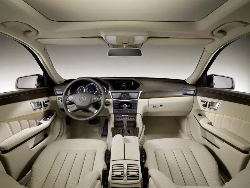 Intérieur luxueux de Mercedes-Benz avec tableau de bord en cuir et boiseries élégantes.