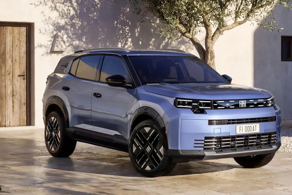 SUV électrique Fiat bleu garé devant une maison moderne ensoleillée.