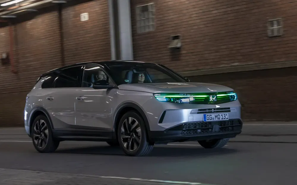 Elektrische Opel Grandland rijdt snel door verlichte stedelijke tunnel.