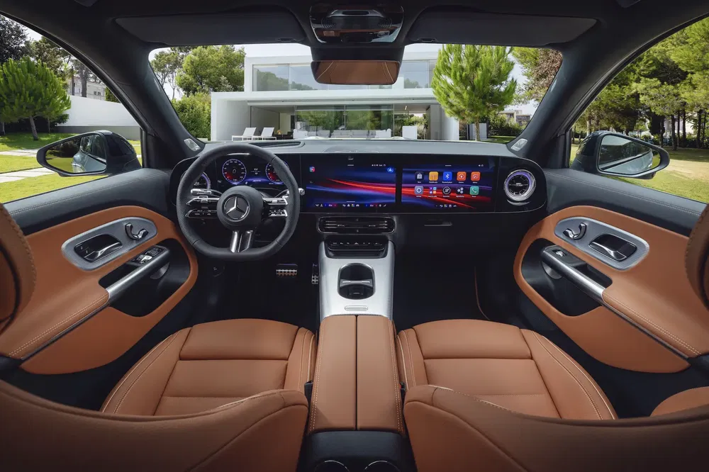 Intérieur luxueux d'une Mercedes-Benz avec tableau de bord numérique et sièges en cuir marron.