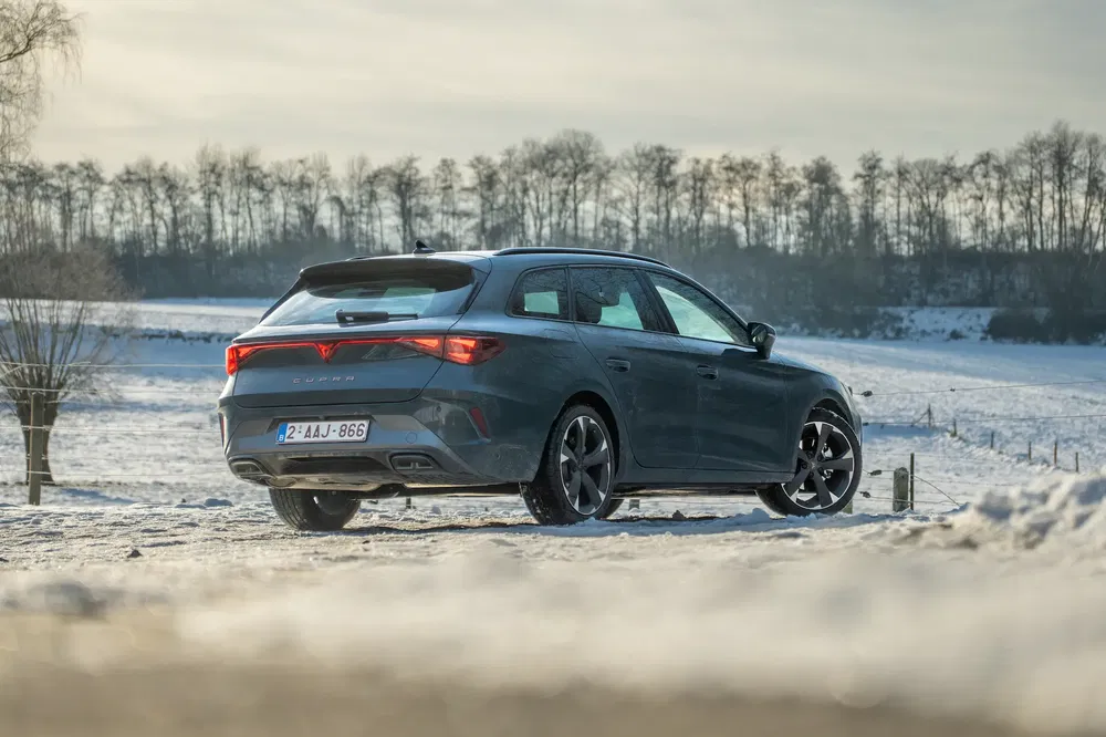 Cupra Leon stationwagen in een besneeuwd winterlandschap.