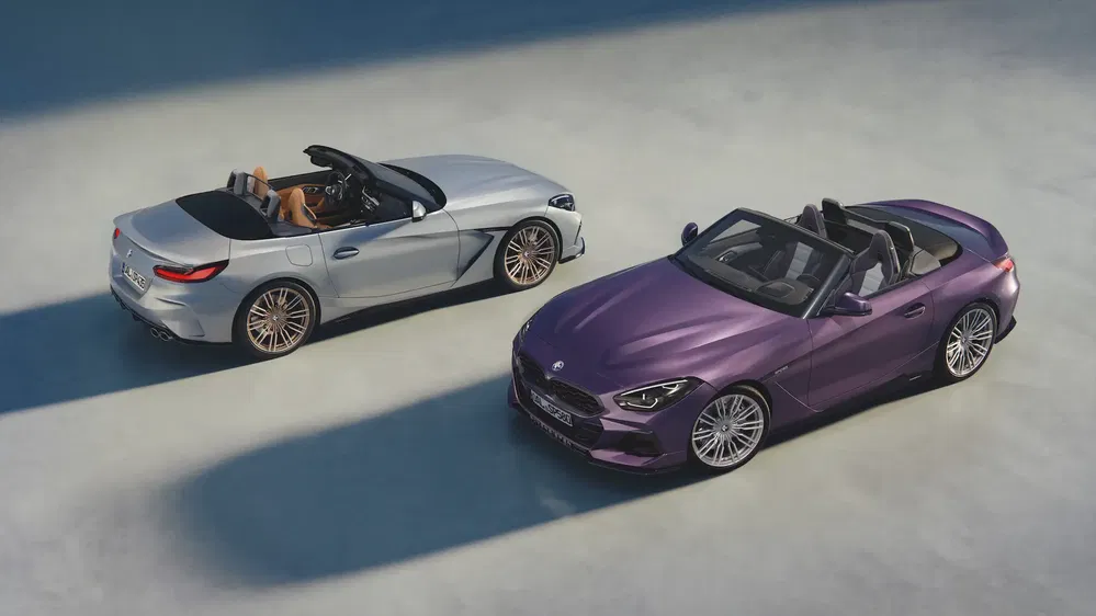 BMW Z4 cabriolets, argent et violet, stationnés côte à côte sur asphalte clair.