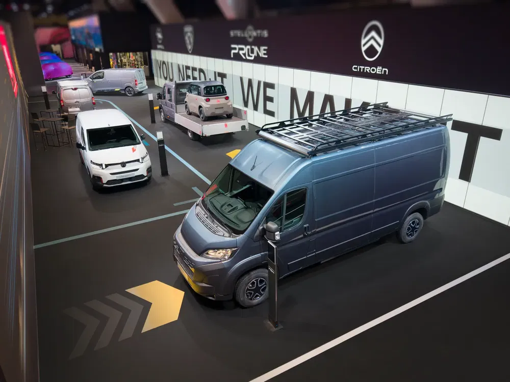 Stand Citroën avec fourgons et utilitaires modernes exposés à un salon automobile.