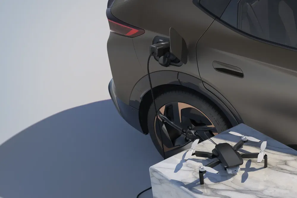 Véhicule électrique en charge avec un drone sur une table en marbre à proximité.