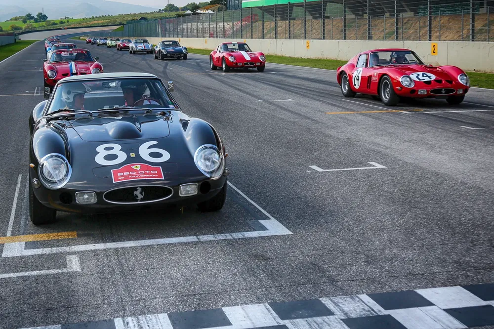 {"fr":"Course de voitures Ferrari classiques sur circuit, avec plusieurs modèles alignés pour départ.","nl":"Klassieke Ferrari auto's racen op circuit, meerdere modellen staan klaar bij de startlijn."}