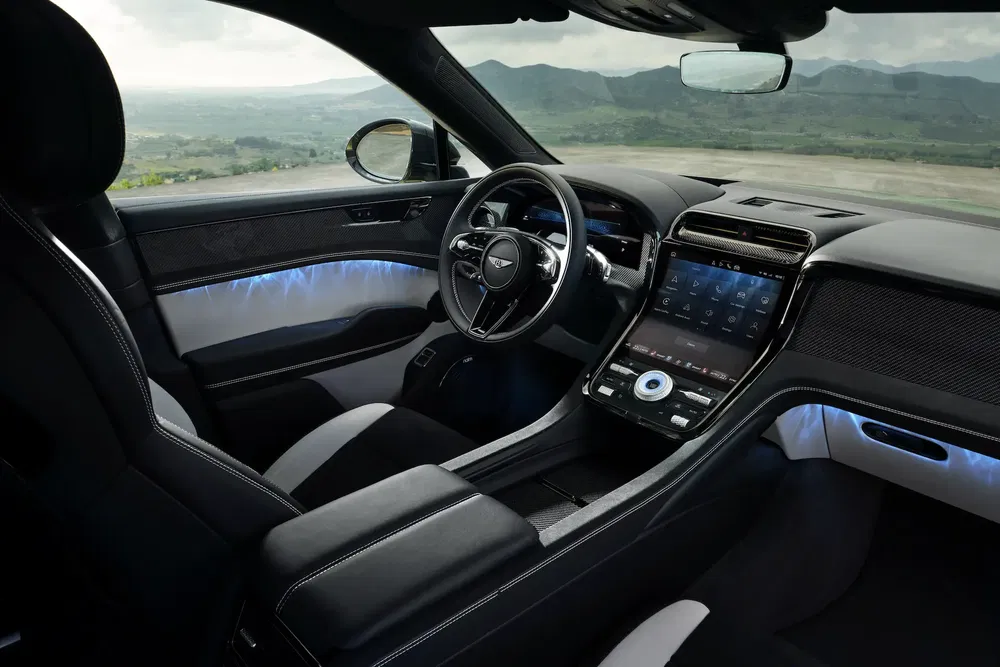 Intérieur luxueux du Genesis GV80 avec tableau de bord numérique moderne et éclairage d'ambiance.