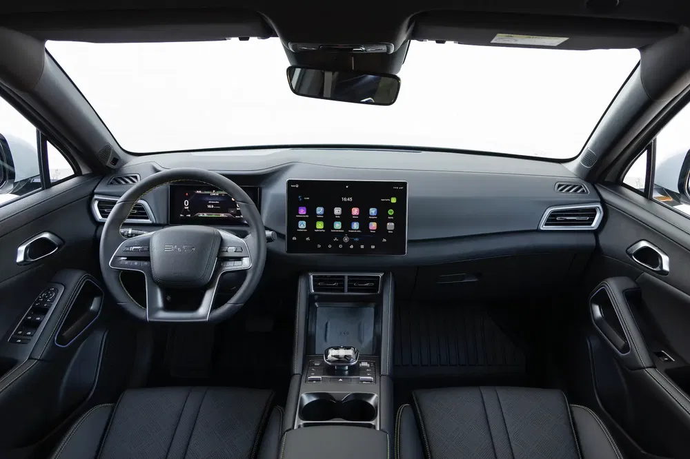 Intérieur moderne d'une voiture Elaris Beo avec écran tactile central et volant multifonctions.