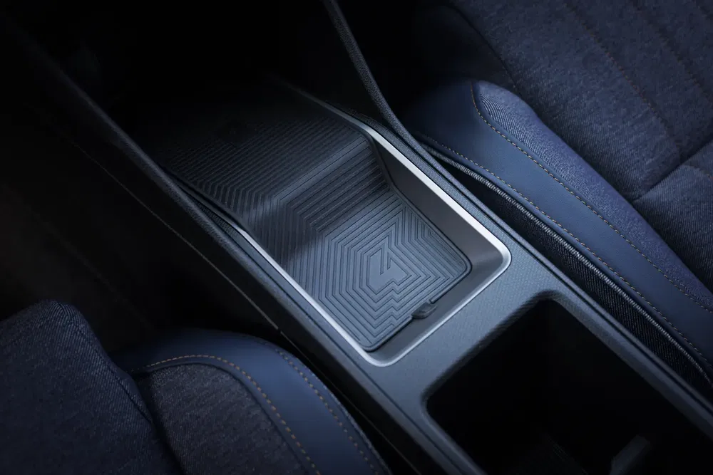 Console centrale avec design texturé dans une voiture moderne, sièges en tissu bleu.