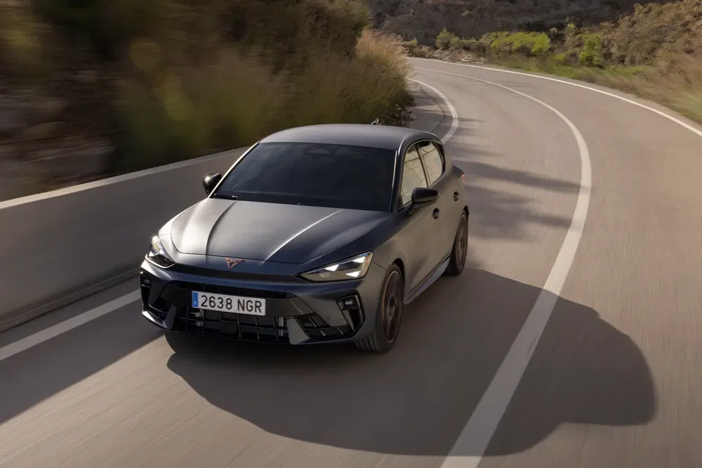 {"fr":"La Cupra Born électrique noire roulant sur une route sinueuse en pleine nature.","nl":"De zwarte elektrische Cupra Born rijdend op een bochtige landelijke weg."}