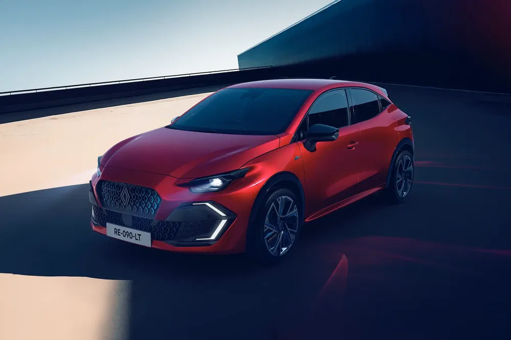 Voiture rouge de sport moderne sur une route, mise en valeur par une lumière naturelle.