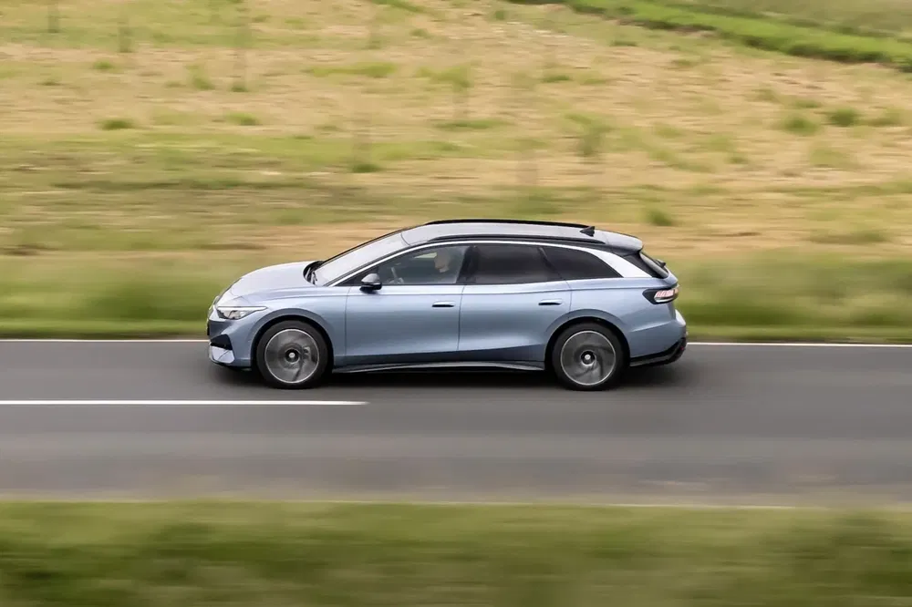 Volkswagen ID.7 break conduisant rapidement sur une route de campagne.