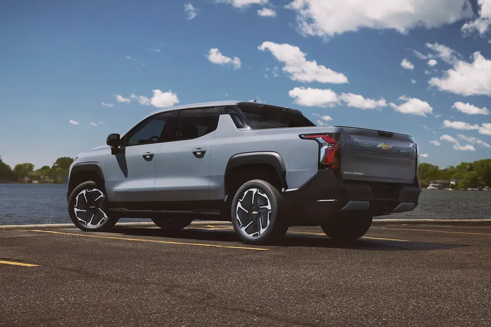 Elektrische Chevrolet Silverado geparkeerd bij een meer op een zonnige dag.