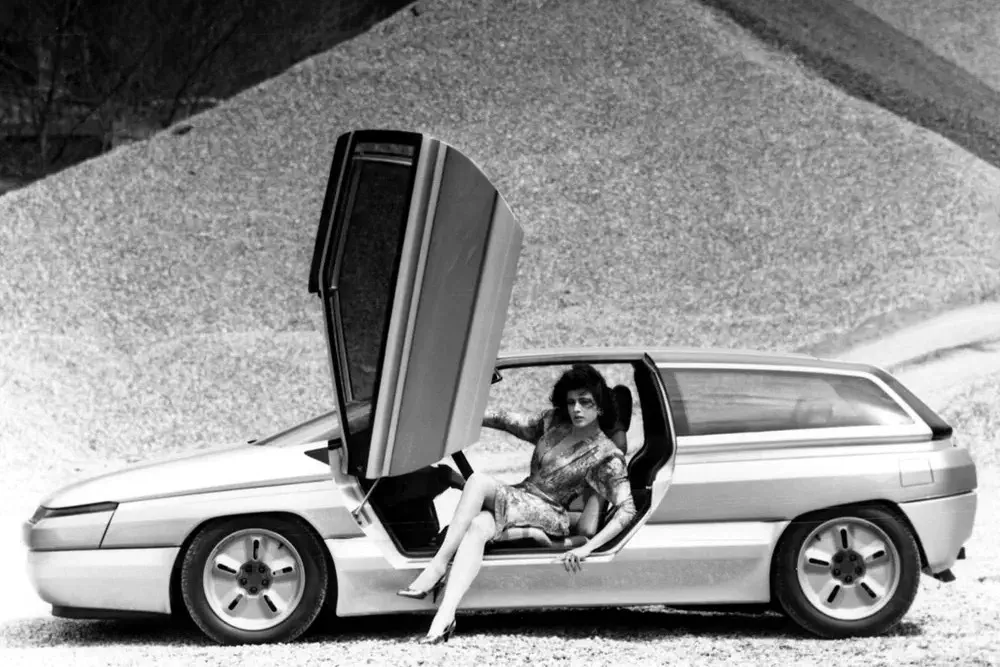 Concept car Citroën XM avec portes papillon ouvertes, femme assise à l'intérieur.