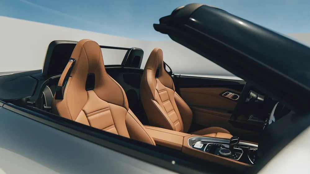 Intérieur de cabriolet avec sièges en cuir beige et tableau de bord moderne.