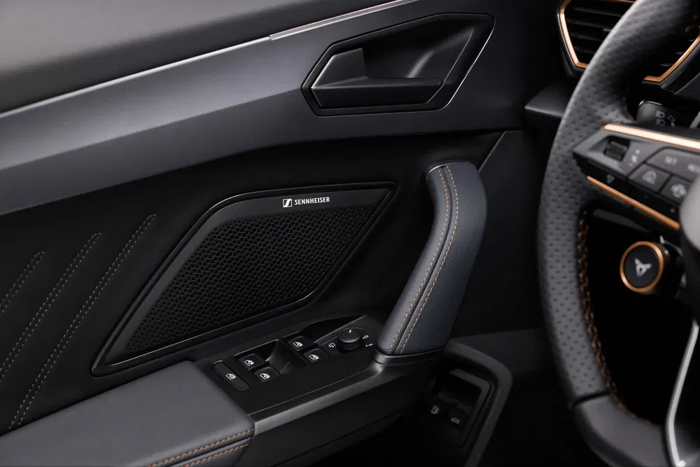 Intérieur de voiture avec système audio Sennheiser et volant moderne.