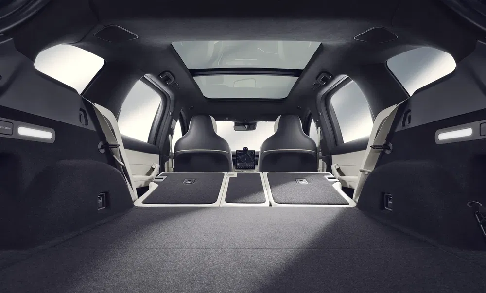 Ruim interieur van elektrische SUV met neergeklapte achterbanken en panoramisch dak.