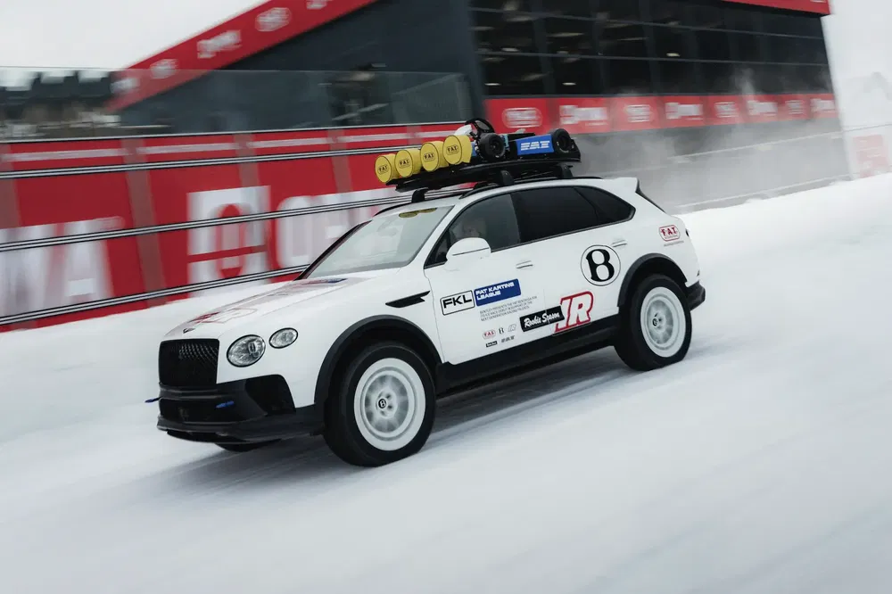 {"fr":"Bentley Bentayga blanc sur piste glacée avec accessoires tout-terrain et numéros de course.","nl":"Witte Bentley Bentayga op ijsbaan met offroad-accessoires en racenummering."}