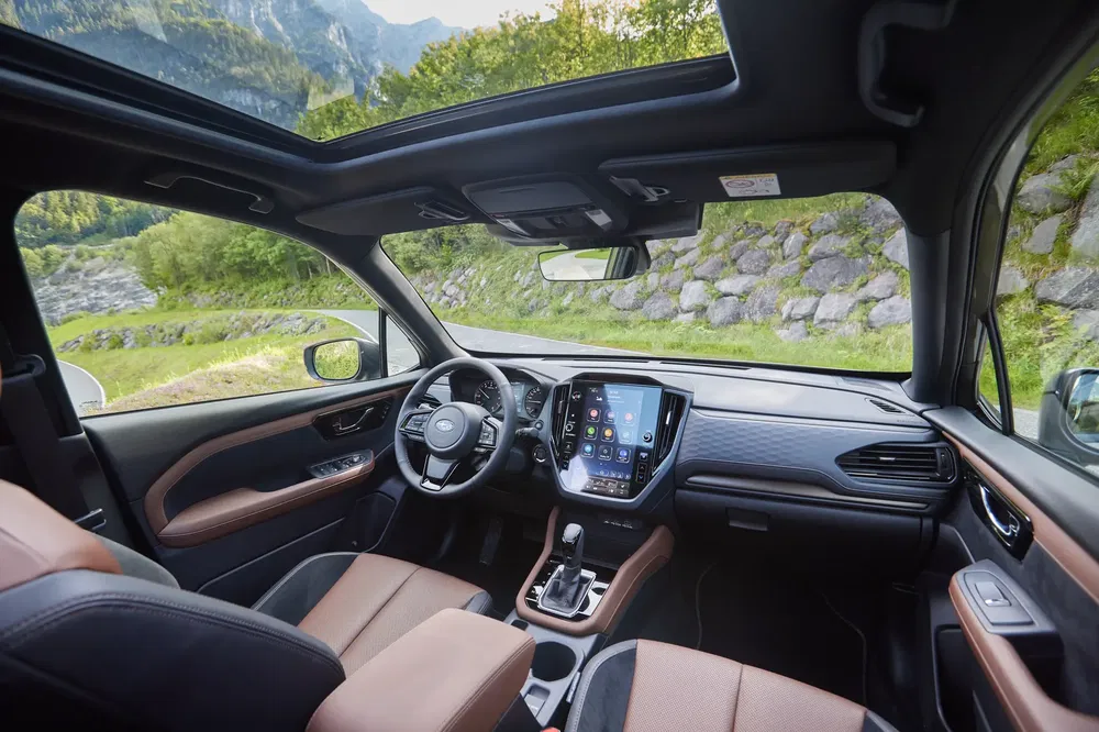 Interieur van Subaru met panoramisch dak en modern dashboard op bergweg.