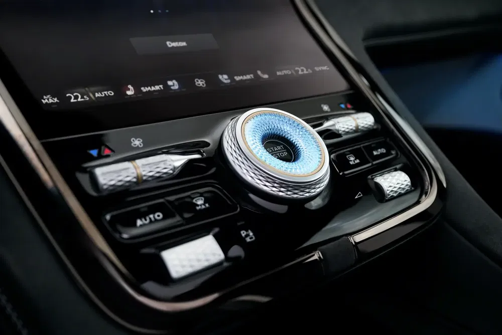 Console centrale du véhicule Hyundai Ioniq 6 avec boutons chromés et démarreur illuminé.
