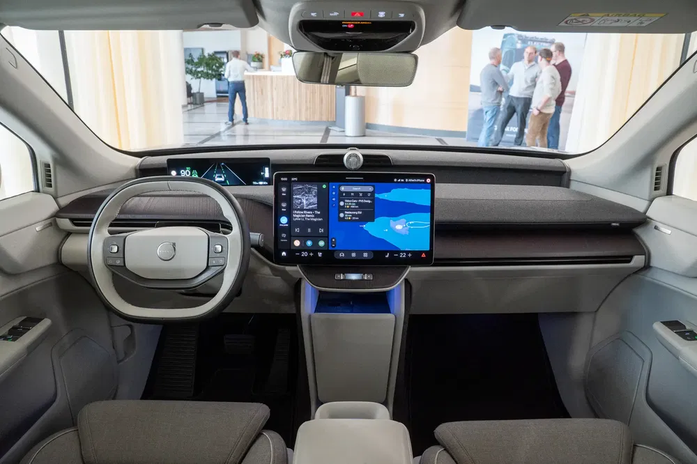 Intérieur moderne d'une voiture électrique avec grand écran tactile et tableau de bord numérique.