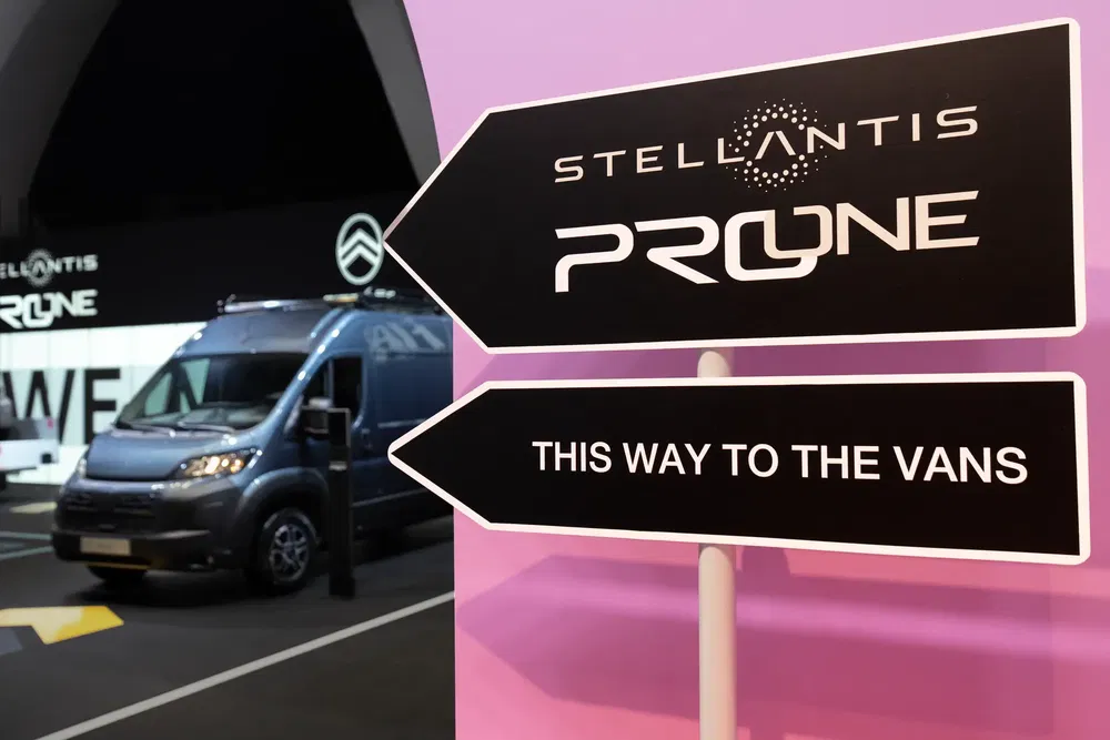 Signalisation Stellantis ProOne avec un van bleu en arrière-plan dans un salon automobile.