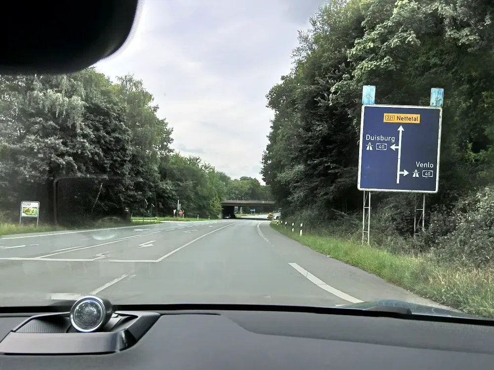 Route vers Nettetal avec panneau de direction pour Duisburg et Venlo, forêt environnante.
